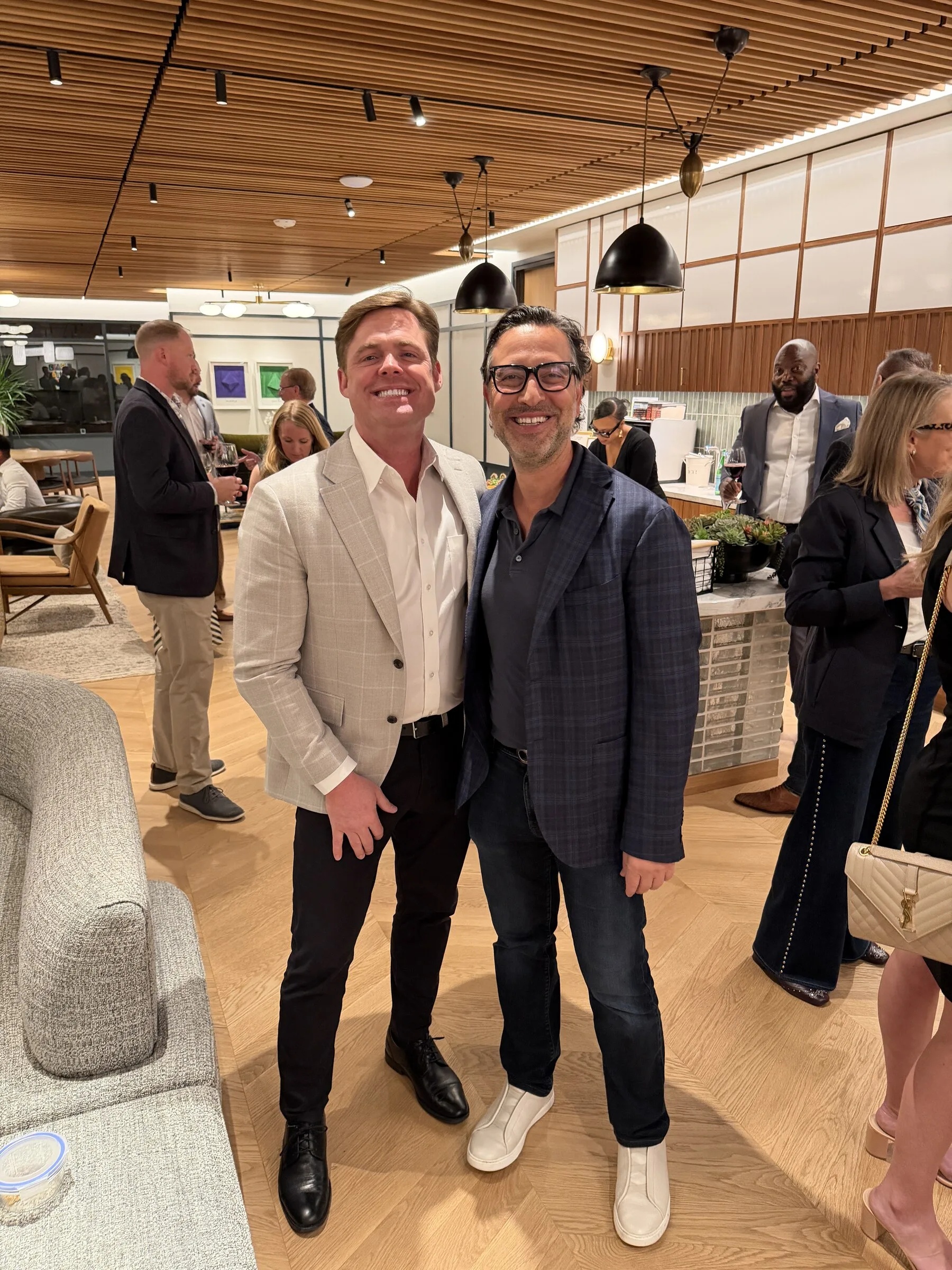 Two guests, one the host, meeting on the room floor at an evening at The Room.